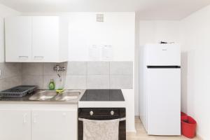 a white kitchen with a sink and a refrigerator at Séjourner chez Roto in Cambronne-lès-Ribécourt
