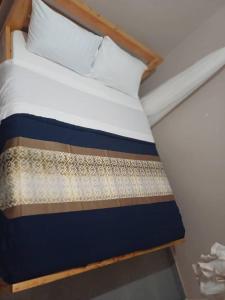 KisoroにあるBetimu Residenceのベッド(木製ヘッドボード、白いシーツ、枕付) +4枚の写真