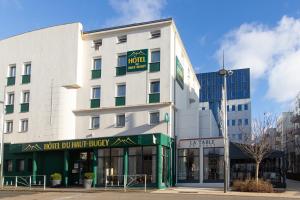 瓦约纳克斯Logis Hôtel du Haut-Bugey的一座白色的建筑,前面有酒店