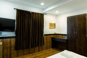a room with a bed and a curtain and a television at CozyKey Rooms Bandra in Mumbai +18 photos