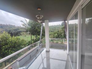 einen Balkon eines Hauses mit Aussicht in der Unterkunft Savisos home in Padinjarathara
