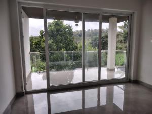 ein leerer Raum mit einem offenen Fenster mit Aussicht in der Unterkunft Savisos home in Padinjarathara