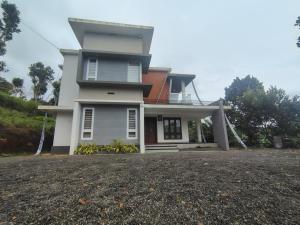 ein großes weißes Haus mit einer Einfahrt davor in der Unterkunft Savisos home in Padinjarathara