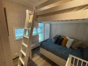 una litera en una habitación con escalera en Cabin on hardangerfjord, 