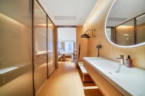 a bathroom with a large sink and a mirror at JI Hotel Hangzhou West Railway Station in Hangzhou +18 photos