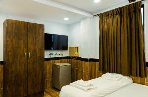 a hotel room with two beds and a tv at CozyKey Rooms Bandra in Mumbai