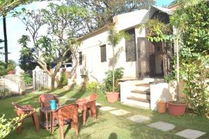 Casa Aranya - A Heritage Retreat في مونت ابو: ساحة بها كراسي وطاولة أمام المنزل