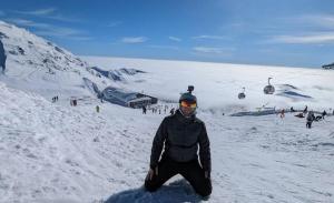 a man sitting in the snow next to a ski lift at Jane's Resort Studio by Tatralandia & Lake in Liptovský Mikuláš +41 photos
