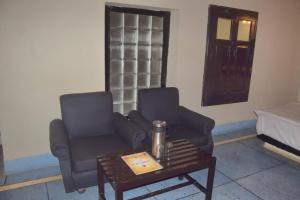Casa Aranya - A Heritage Retreat في مونت ابو: غرفة معيشة مع كرسيين وطاولة قهوة