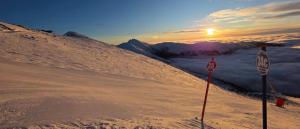 a stop sign on a snow covered slope with the sunset at Jane's Resort Studio by Tatralandia & Lake in Liptovský Mikuláš
