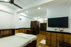 a bedroom with a bed and a flat screen tv at CozyKey Rooms Bandra in Mumbai