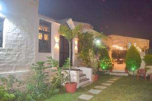 Casa Aranya - A Heritage Retreat في مونت ابو: منزل به مجموعه من النباتات في الساحه +صورتان