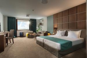 een hotelkamer met een bed en een woonkamer bij Hotel Pomorie Sun in Sunny Beach +23 foto's