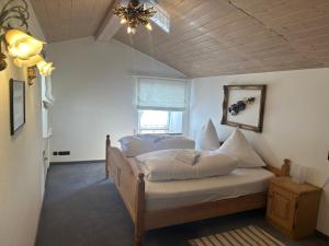 a bedroom with a bed with white sheets and a window at Ferienwohnungen Roderer in Berchtesgaden