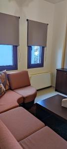 Una sala de estar con un sofá y dos ventanas. en LightHouse Portaria, en Portaria