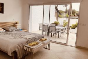 Spacious house in Tarnos near the beach في تارنوس: غرفة نوم بها سرير وطاولة وكراسي