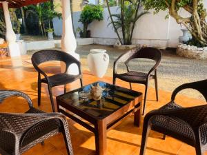 a group of chairs and a coffee table in a patio at Ayurveda Villa Rob Roy in Beruwala
