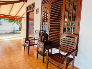 a room with two wooden chairs and a table at Ayurveda Villa Rob Roy in Beruwala
