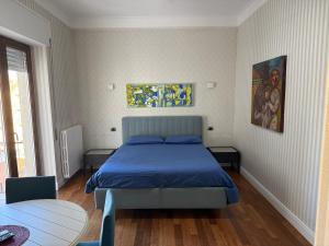 a bedroom with a blue bed and a table at Leonardo rooms in Avellino +21 photos