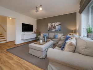 un soggiorno con due divani e una TV di Dacklünen a Wenningstedt