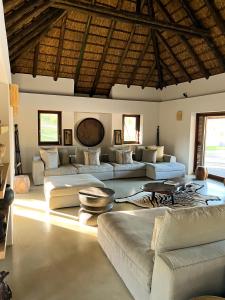 a large living room with couches and tables at Ilanga Lodge Welgevonden Game Reserve in Welgevonden Game Reserve