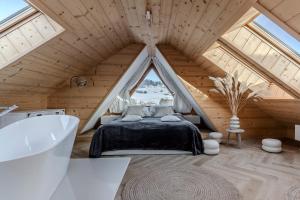 a bedroom in a attic with a bed and a tub at Czorna Chata u Chocyków in Czarna Góra