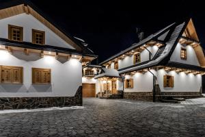 a row of white houses at night with lights at Czorna Chata u Chocyków in Czarna Góra