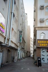 une rue vide dans une ville avec de grands immeubles dans l'établissement GW Hostel, à Mascate