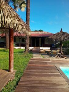 a resort with a wooden walkway next to a pool at La Villa des Palmiers Bleus - Piscine & Jardin in La Valère