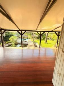 an empty room with a wooden floor and a large tent at La Villa des Palmiers Bleus - Piscine & Jardin in La Valère