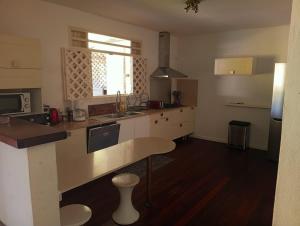 a kitchen with white cabinets and a counter top at La Villa des Palmiers Bleus - Piscine & Jardin in La Valère