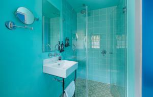 a blue bathroom with a sink and a shower at Scarlet Hotel in Tel Aviv +38 photos