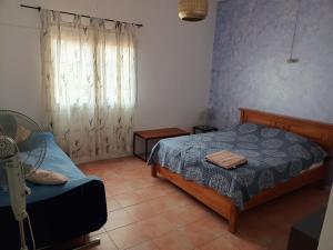 a small bedroom with a bed and a window at Charmante villa avec piscine proche plage in Flic-en-Flac +13 photos