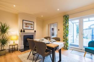 a dining room with a table and a fireplace at Middle Cottage by Keepers Cottages in Sandwich