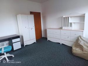 a bedroom with white cabinets and a desk and a chair at Apartament z Jacuzzi in Częstochowa