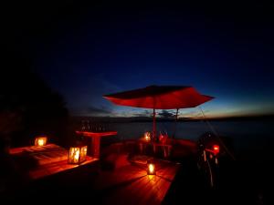 a table with a red umbrella and lights on a boat at Saimaa Experience in Savonlinna