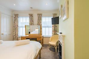 a bedroom with a bed and a desk and a mirror at Middle Cottage by Keepers Cottages in Sandwich