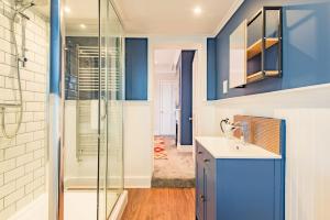 a bathroom with blue walls and a sink and a shower at Middle Cottage by Keepers Cottages in Sandwich +22 photos