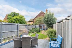 a patio with two blue chairs and a fence at Middle Cottage by Keepers Cottages in Sandwich
