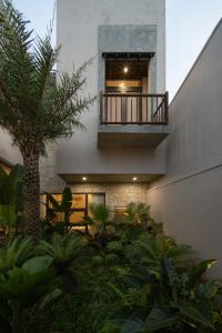 a building with a balcony and a palm tree at MOONLIGHT Homestay & Hotel in Pleiku