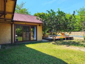una casa con un patio con un árbol en Villa Pesisi - 3 bdrs - beach walking distance, en Selong Belanak