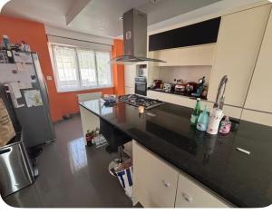 a kitchen with a black counter top and a refrigerator at Chez Soiz in Guipavas