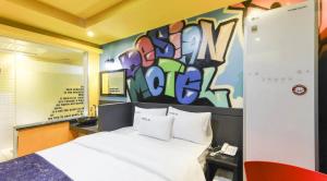 a bedroom with a bed and a wall with graffiti at Jukdo market G1mini in Pohang