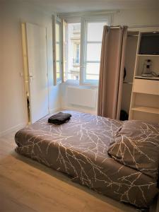 ein Bett in einem Zimmer mit einem Fenster in der Unterkunft Studio dans l'hypercentre de Limoges in Limoges