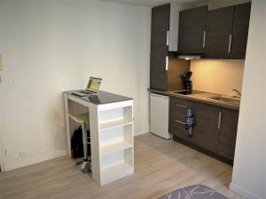 eine Küche mit einem Tisch und einem Laptop darauf in der Unterkunft Studio dans l'hypercentre de Limoges in Limoges + 1 Foto