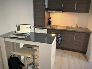 a laptop computer sitting on a desk in a kitchen at Studio dans l'hypercentre de Limoges in Limoges