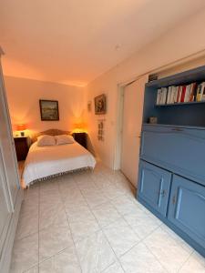 a bedroom with a bed and a blue cabinet at Charmant T2 à 100m de la plage in Bénodet