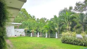 uma cerca em frente a um quintal com palmeiras em Villa De'YuLee em Negombo