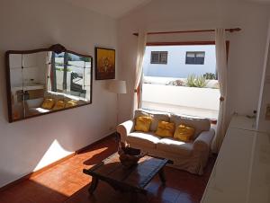 een woonkamer met een bank en een spiegel bij Casa Brisamar in Puerto del Carmen