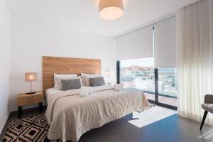 een slaapkamer met een groot bed en een groot raam bij Villa view bay with Jacuzzi in Salir de Porto +22 foto's